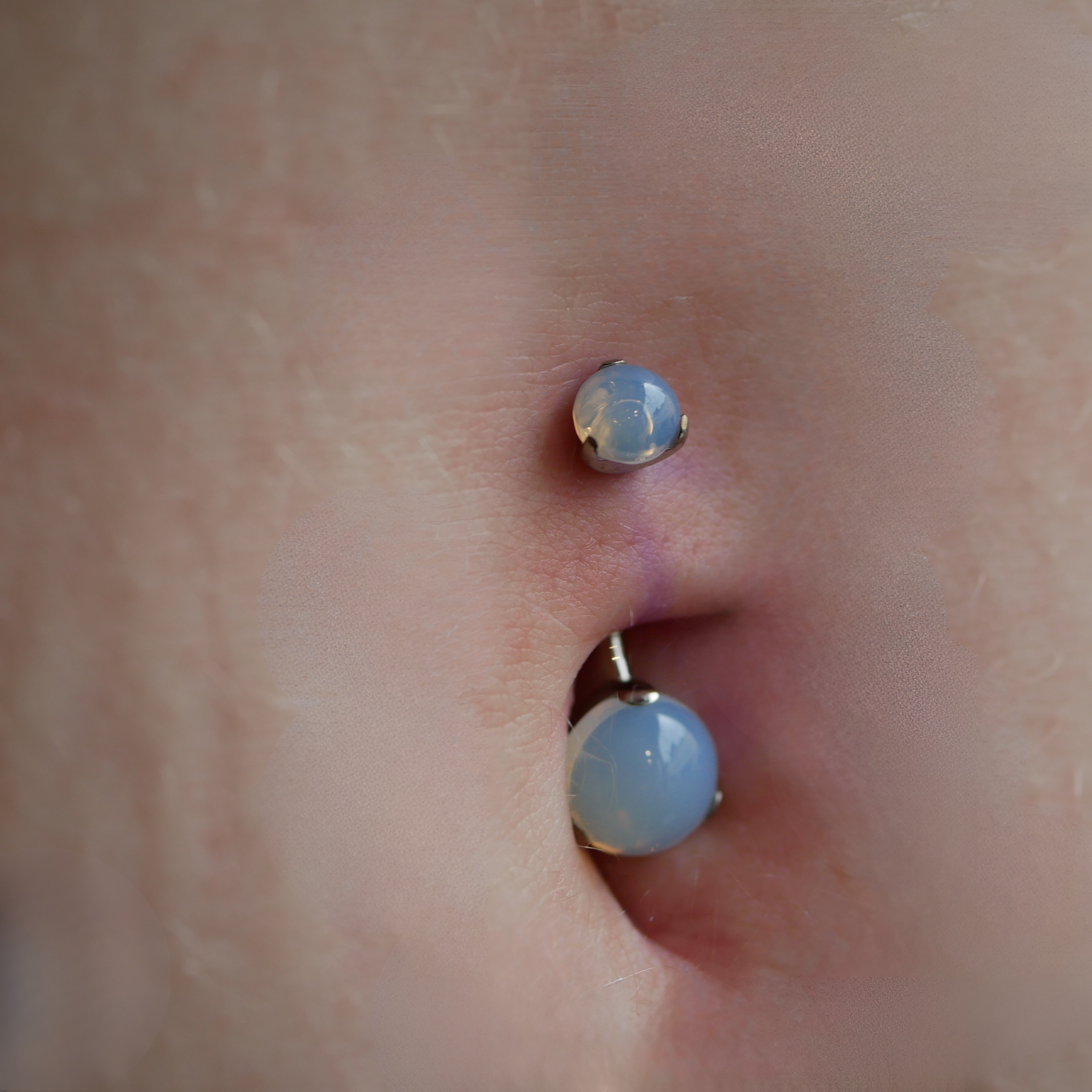 photo d'une piercing au nombril avec un bijou en titane et pierre de lune disponible chez kawaii place a lille