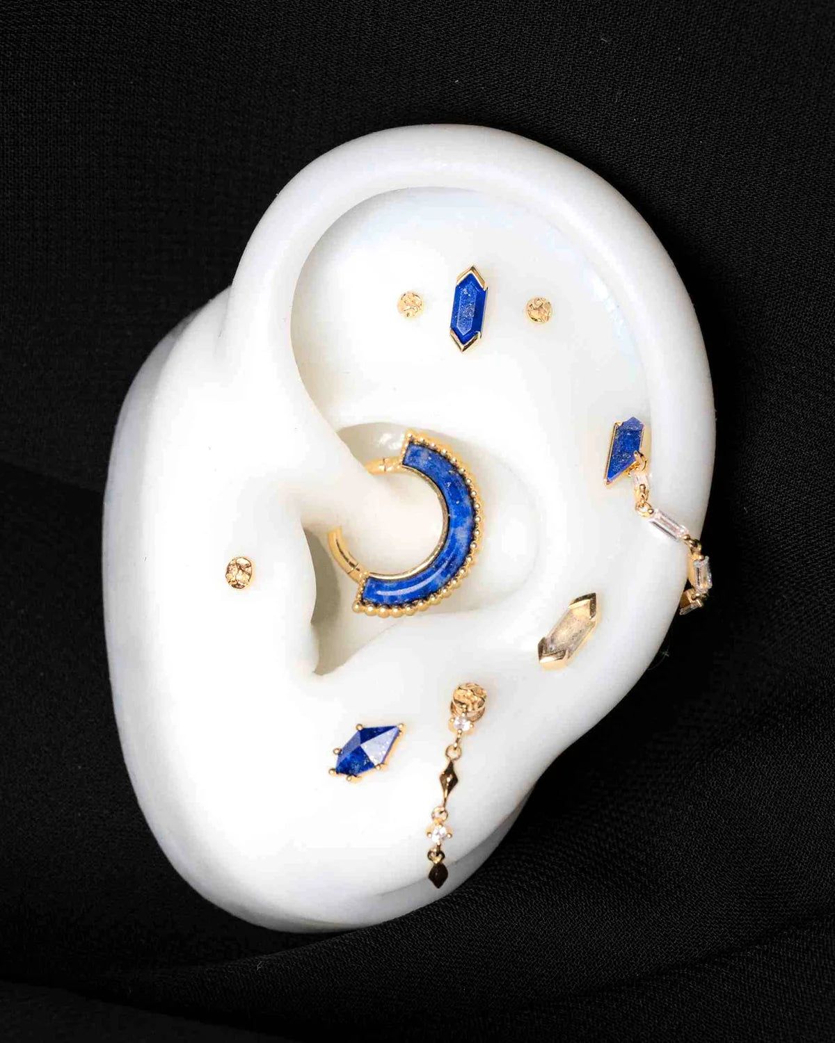 Bijou Reputation en or 14k serti d’un lapis-lazuli bleu profond, adapté à plusieurs piercings comme le tragus, le lobe ou l’hélix.