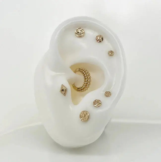 Hammered Disk en or 14k, bijou à texture martelée inspirée de l’artisanat, apprécié pour son éclat subtil et son style délicatement travaillé.