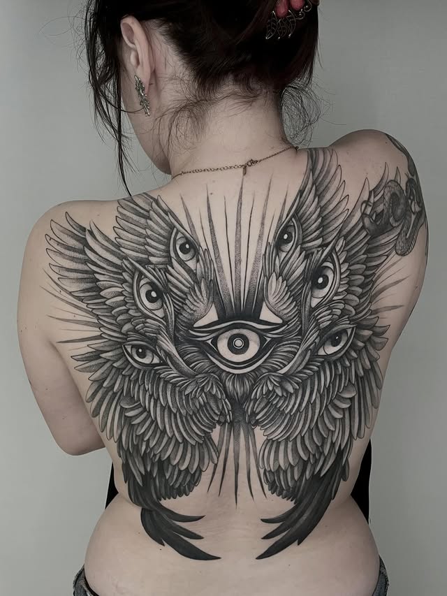 photo d'un dos tatoué par mylène obscurae avec des yeux et des ailles chez kawaii place a lille