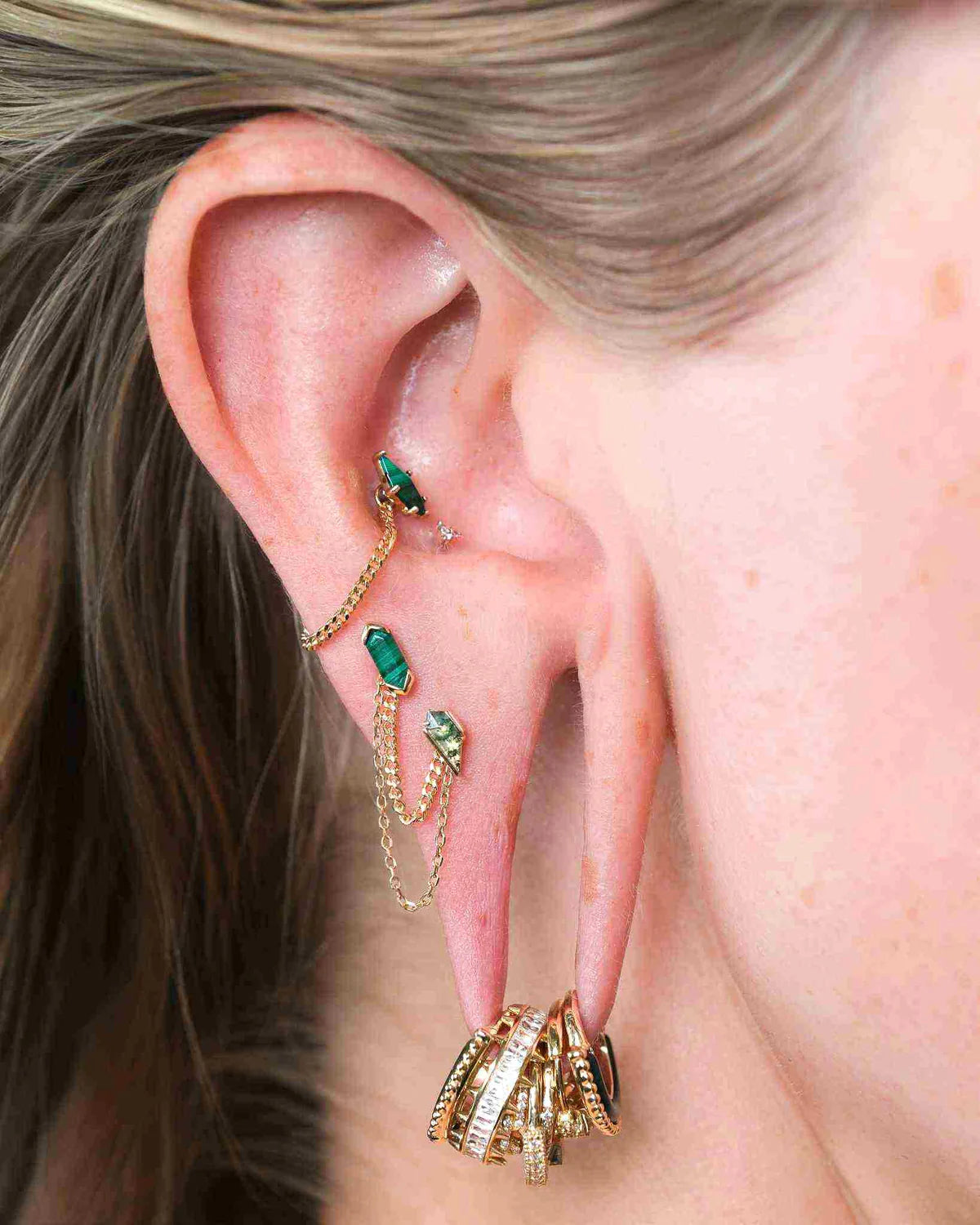 Bijou Mystic en or 14k avec malachite porté sur un piercing tragus, offrant un rendu élégant et discret proposé chez Kawaii Place à Lille.