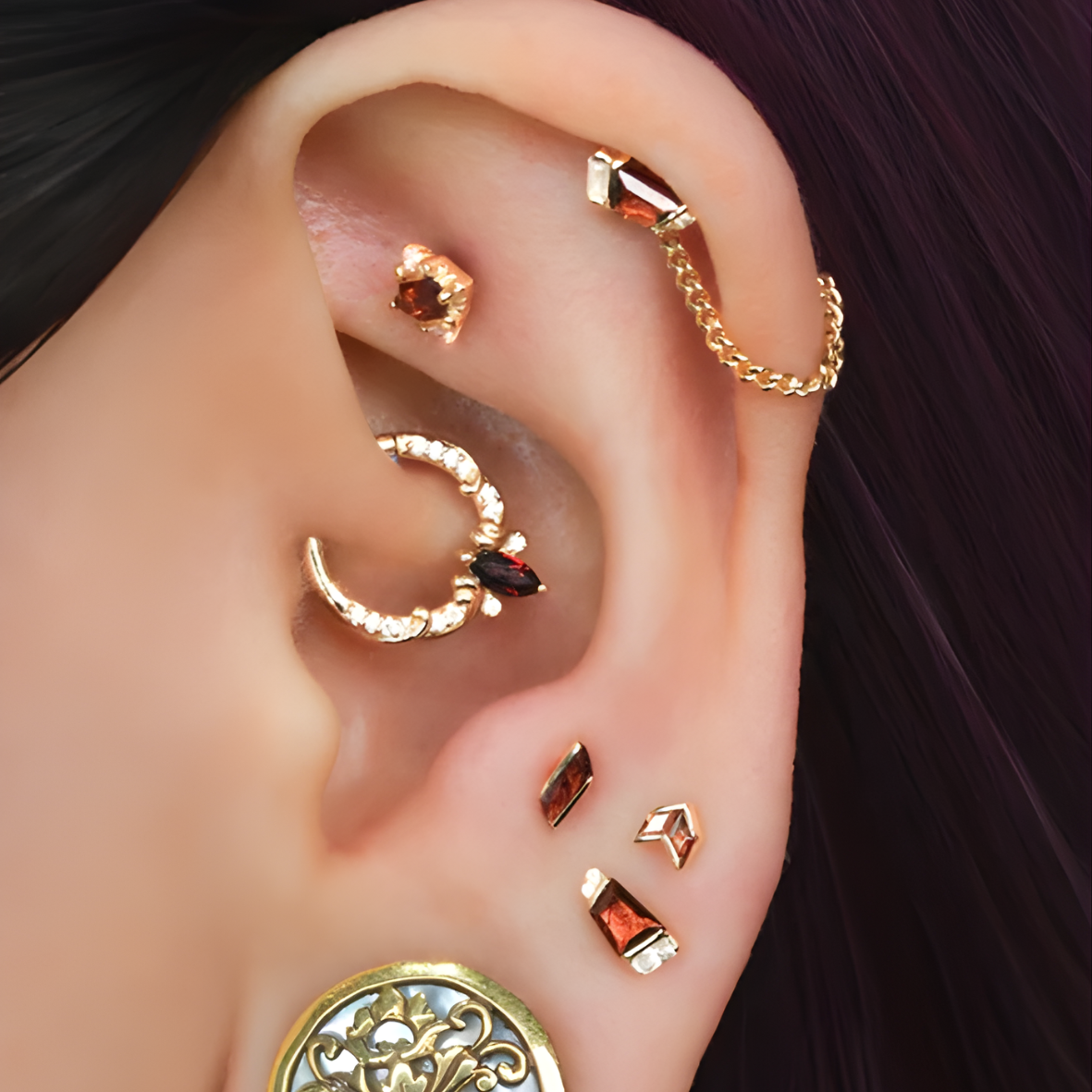 Bijou Coterie en or 14k avec grenat rouge porté sur un piercing daith, montrant le rendu élégant proposé chez Kawaii Place à Lille.