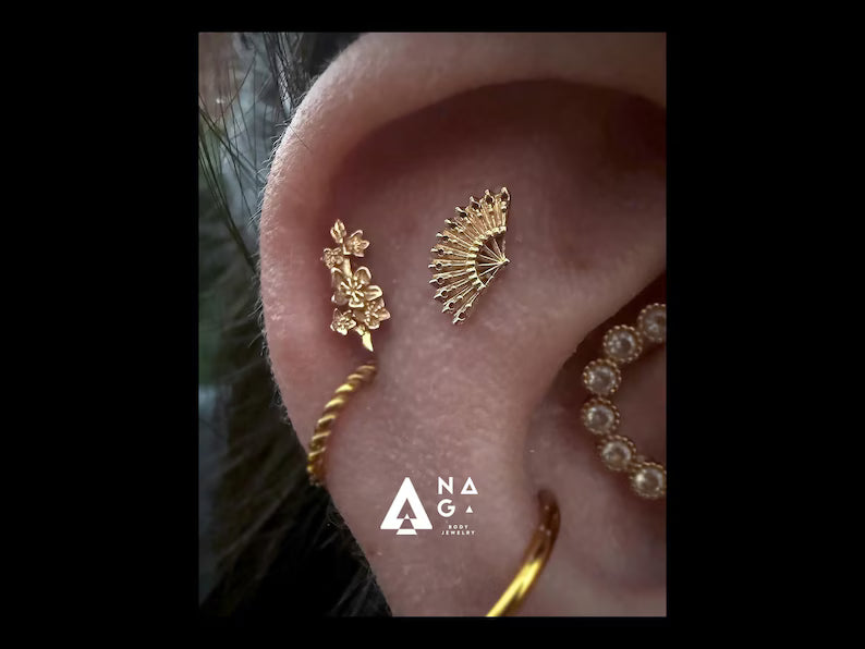 Bijou Naga Edena en or 14k porté sur un hélix, offrant un rendu lumineux et discret, disponible dans notre studio de piercing Kawaii Place.